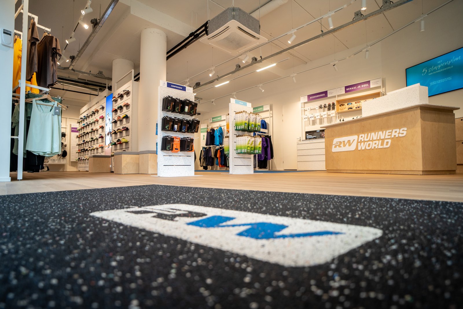 Interior of Runnersworld Eindhoven, a Dutch running specialty retailer, showing the in-store collection point near the till